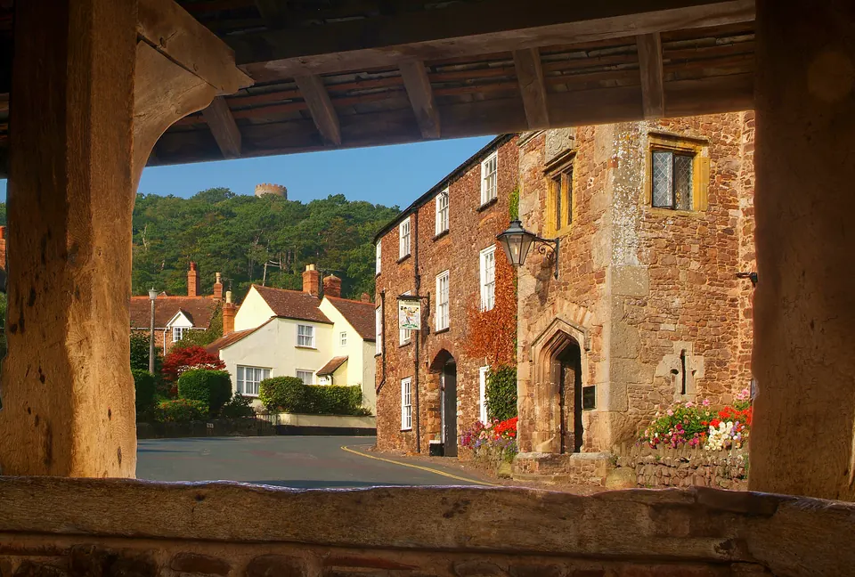 The Luttrell Arms frontage framed by Yarn Market timbers, with Conygar Tower beyond