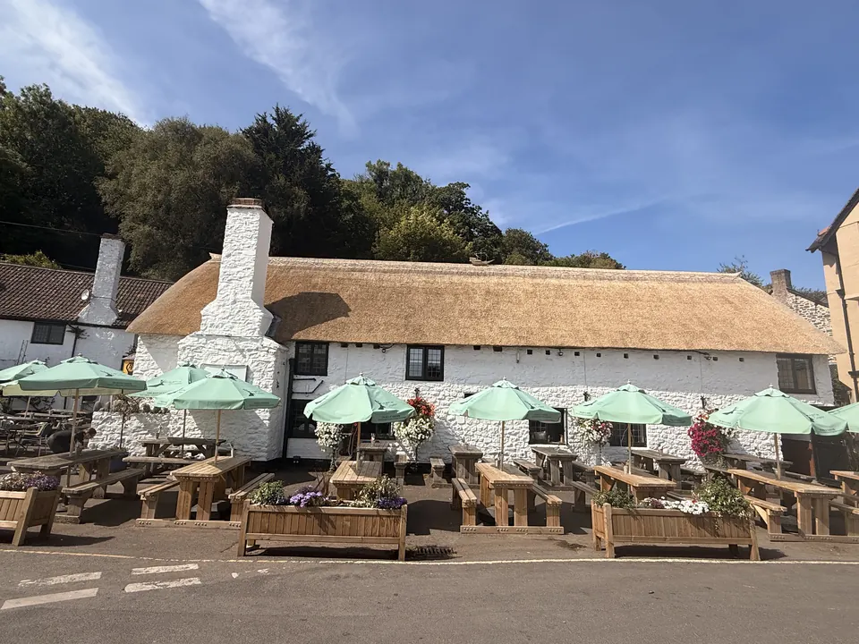 Thatched exterior and outdoor tables at The Ship Inn, Porlock Weir