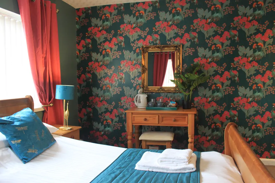 A bedroom with floral wallpaper at the Waverley Bed and Breakfast